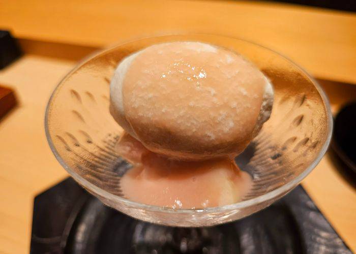 Wasanbon (fine-grained Japanese sugar) ice-cream and peaches, served in a glass dish.